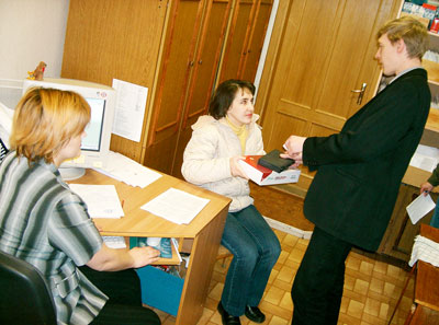 Специалист по маркетингу Наталья Заливина (крайняя слева) и инженер-электроник Виктор Локтев, занимающиеся внедрением Интернет-услуг, вручают ADSL-модем новому абоненту.